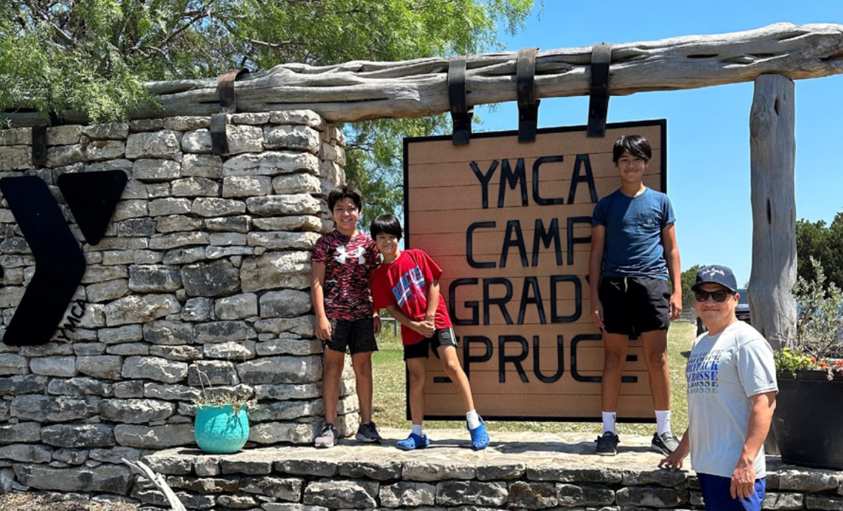 kids standing in front of a camp grady spruce sign