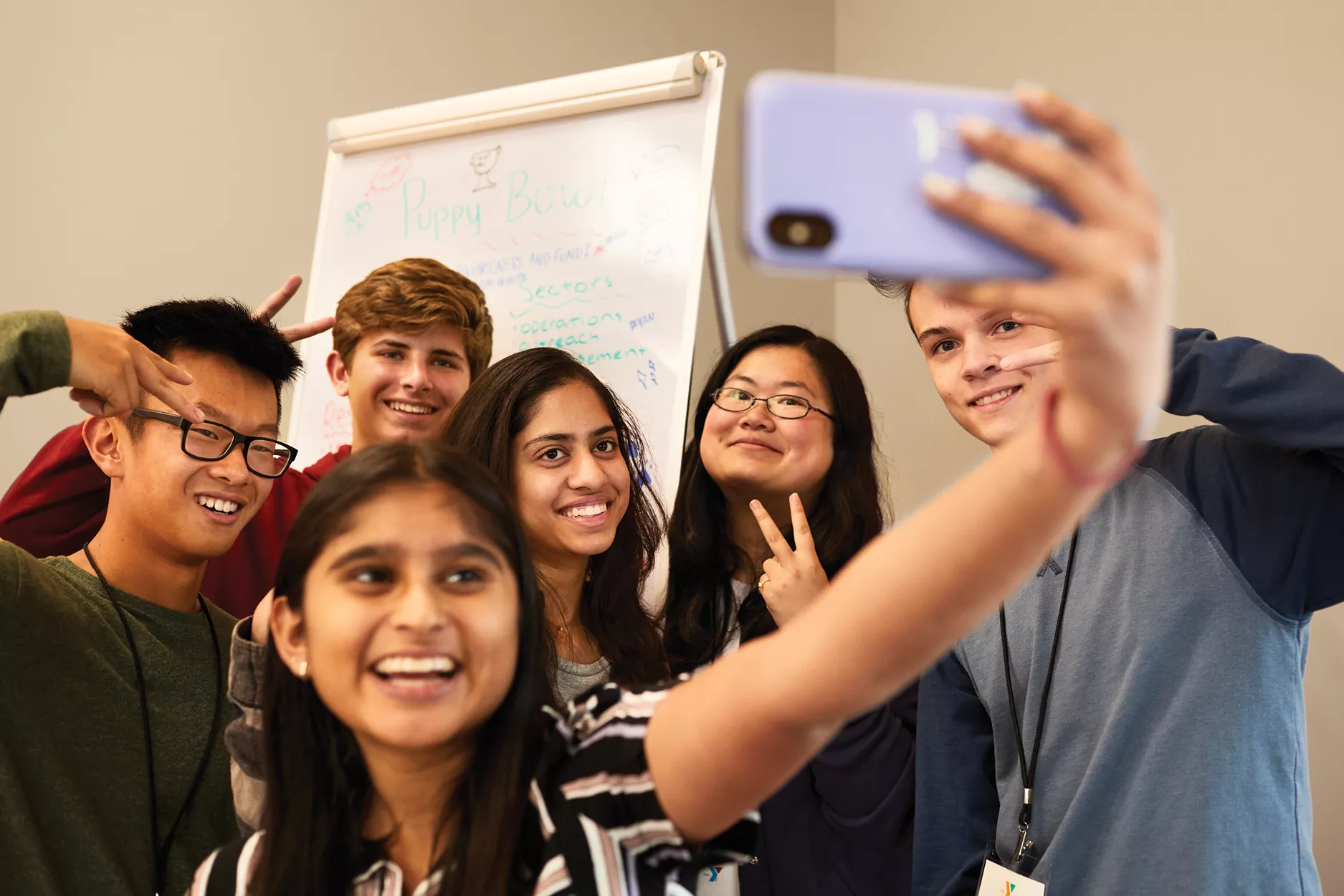 A group of middle school students smiling and posing for a selfie