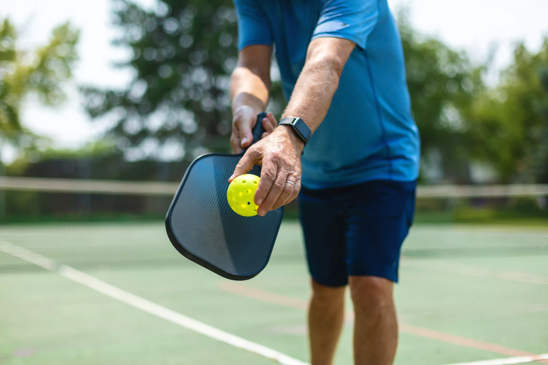 Mature White Adult In Position For Serve During Outdoor Pickleball 