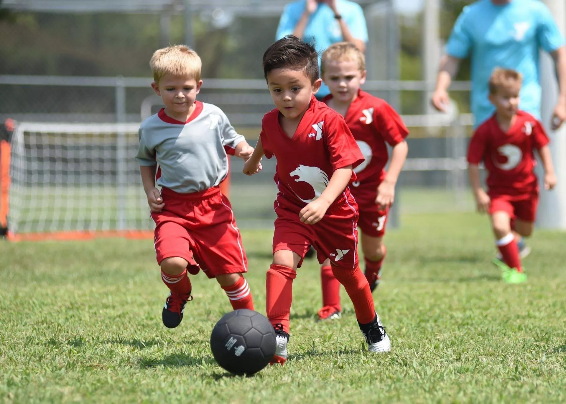 kids playing soccer in red uniforms