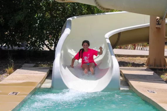 girl sliding down a white slide