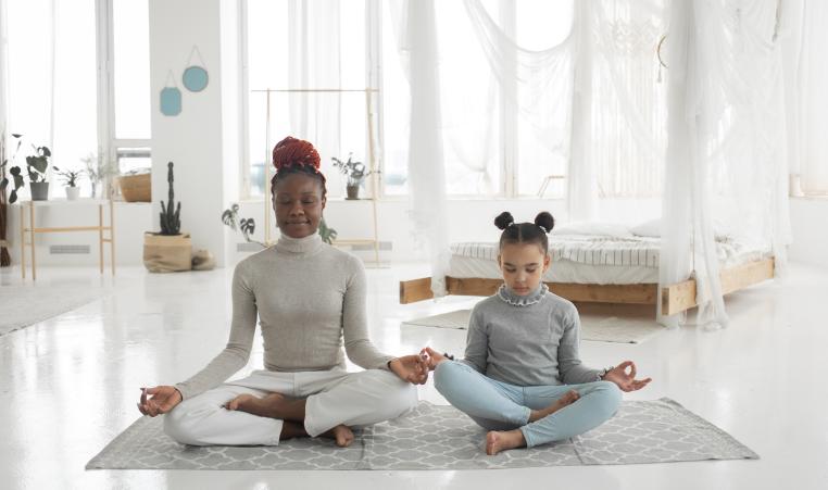 African American Woman and Kid Meditating Yoga