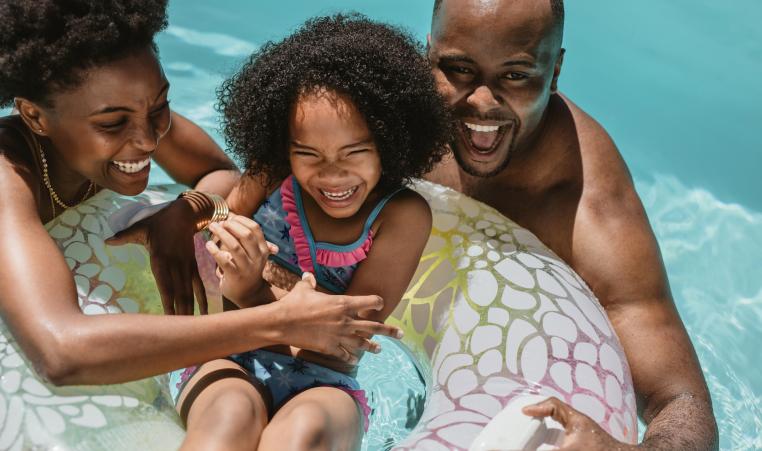 Family enjoying summer holidays in pool stock photo