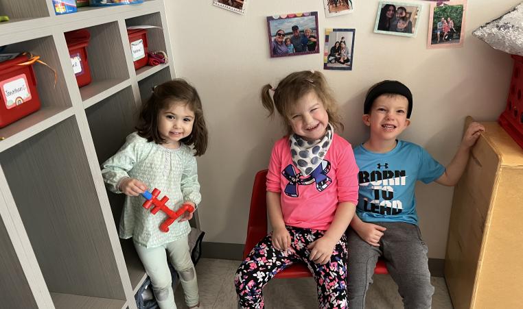 3 students smiling in a classrom