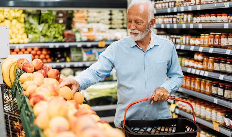 Retired man buying groceries - fruits and vegetables stock photo