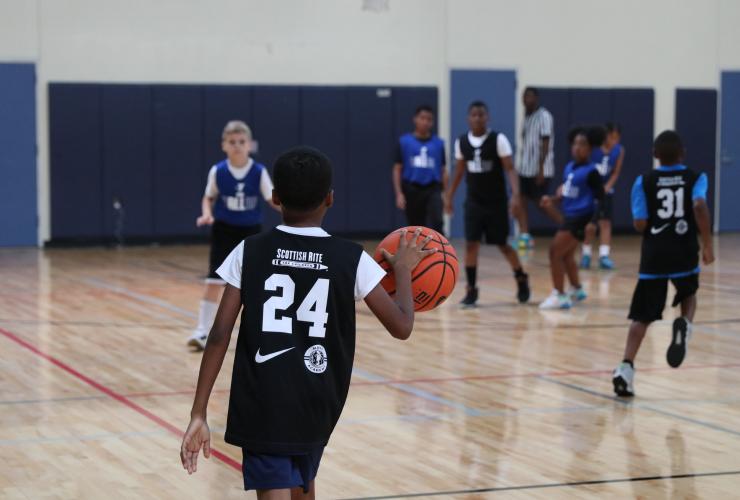 Kids playing basketball with Scottish Rite for Children jersey